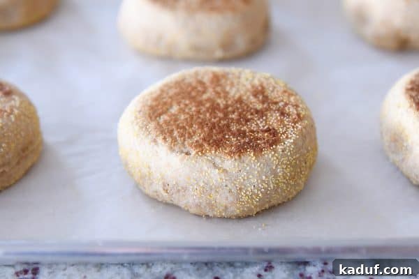 Baked english muffin on parchment lined baking sheet.