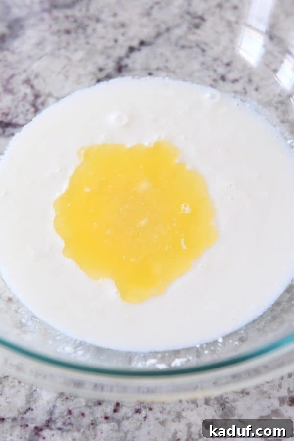 Adding butter to buttermilk for english muffin batter.