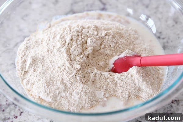 Stirring in dry ingredients to english muffin batter.