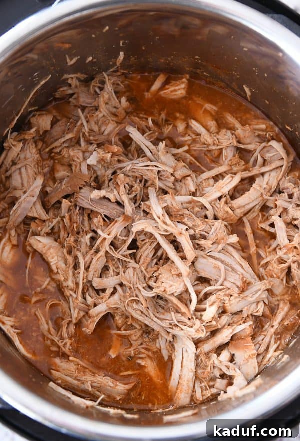 Tender BBQ Pork Tacos Instant Pot Slow Cooker Friendly 6 A close-up of perfectly cooked and shredded BBQ pork, coated in a luscious sauce and ready to be served in delicious Instant Pot BBQ pork tacos.