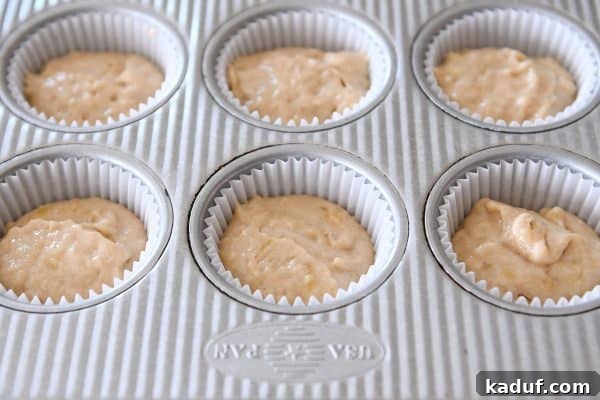 Irresistible Banana Muffins 10 Raw banana muffin batter nestled in paper liners, ready for the oven.