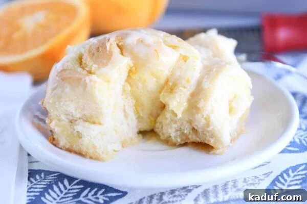 Sun-Kissed Orange Swirl Rolls 4 Spiral rolled homemade orange sweet roll.