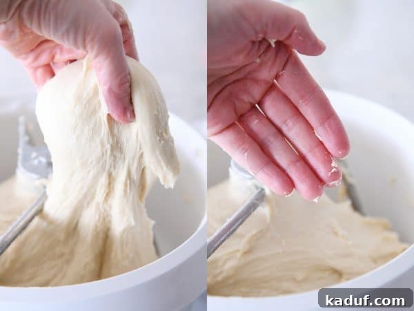 Melt-in-Your-Mouth Homemade Glazed Donuts 8 Lifting silky, stretchy dough out of a Bosch mixer, demonstrating perfect consistency for homemade glazed donuts.