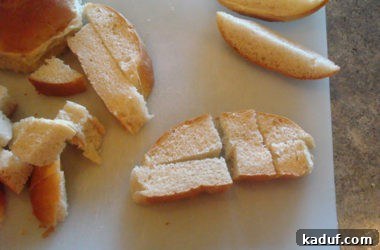 Bread strips are precisely diced into uniform 1/2 to 3/4-inch cubes on a white cutting board, creating the perfect base for gourmet croutons.