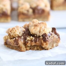 A delicious caramel peanut butter cookie bar with a bite taken out.