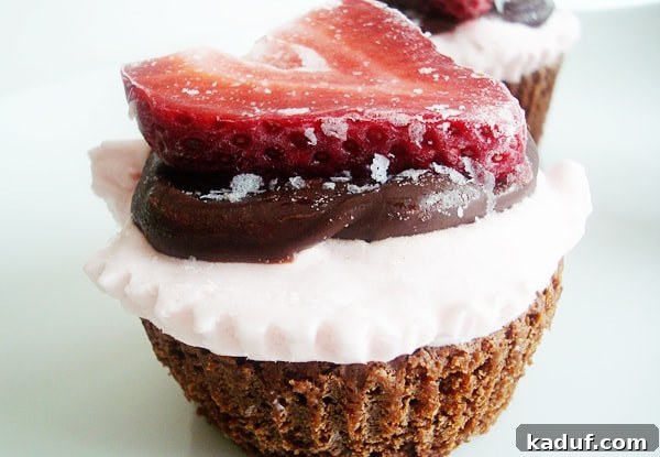 Fudgy Strawberry Ice Cream Brownie Cupcakes 2 Chocolate cupcake with whipped cream, chocolate sauce, and a sliced strawberry.