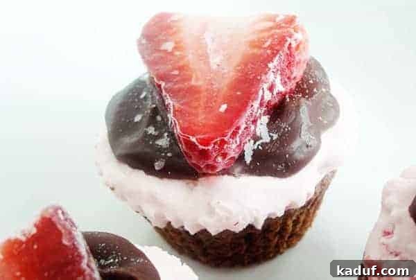 Fudgy Strawberry Ice Cream Brownie Cupcakes 3 Chocolate cupcake with whipped cream, chocolate, and a sliced strawberry on top.