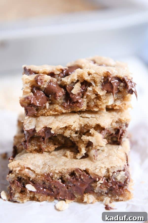 Ultimate Oatmeal Chocolate Chip Coconut Cookie Bars 2 Stack of three oatmeal chocolate chip coconut cookie bars on white napkin.