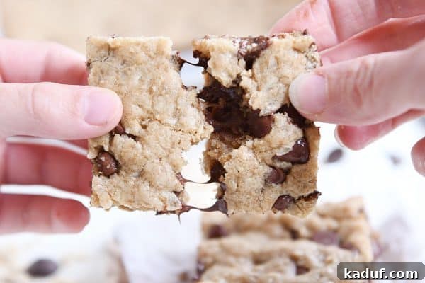 Ultimate Oatmeal Chocolate Chip Coconut Cookie Bars 9 Pulling apart two halves of a warm oatmeal chocolate chip coconut cookie bar.