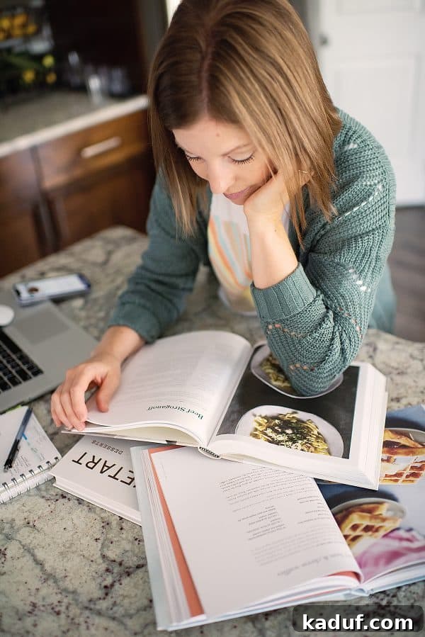 Stress-Free Thanksgiving Dinner Planning Free Printable 2 A host joyfully reviewing Thanksgiving recipes with our comprehensive planner