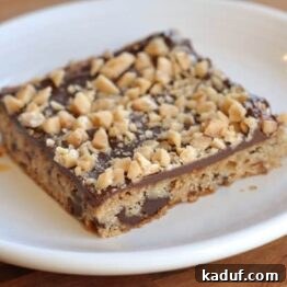 Close-up of a perfectly baked chocolate toffee shortbread bar, ready to be enjoyed.