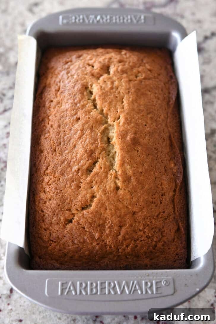 Luscious Buttermilk Banana Bread 8 Top down view of a perfectly cooked loaf of banana bread in a metal Farberware bread pan, golden brown and risen.