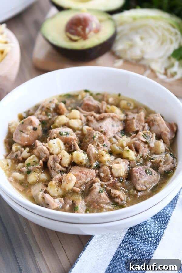 Easy Slow Cooker Posole 7 White bowl with slow cooker posole on wood board.