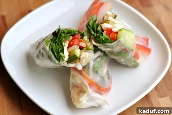 How to Make Fresh Vietnamese Spring Rolls 2 Cut open spring roll on a white plate, showcasing fresh ingredients.