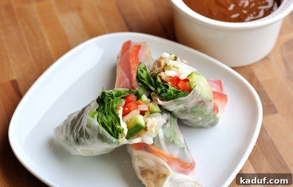 How to Make Fresh Vietnamese Spring Rolls 4 Spring roll cut in half on top of a full spring roll, revealing colorful layers.