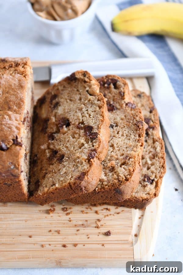 Ultimate Peanut Butter Banana Bread 5 Slices from loaf of peanut butter banana bread on wood cutting board.