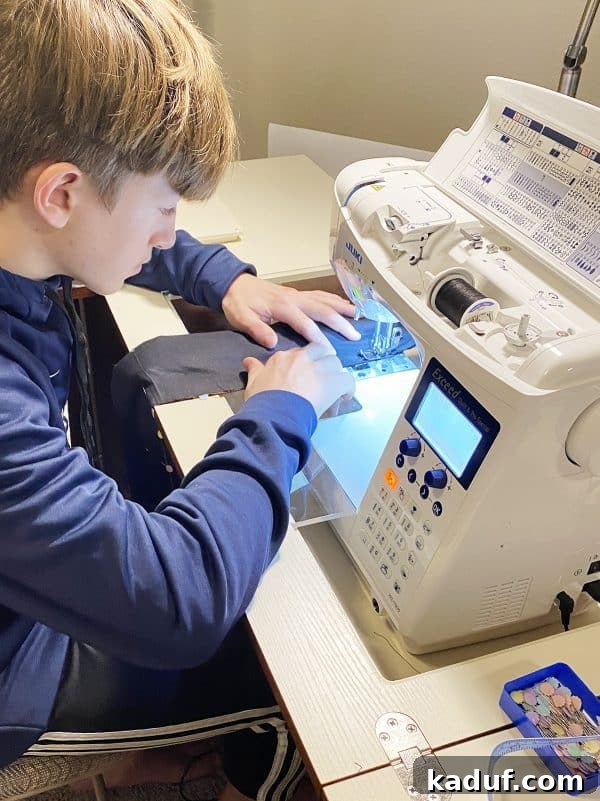 Friday Musings 5 a teenage boy thoughtfully sewing black fabric with a sewing machine