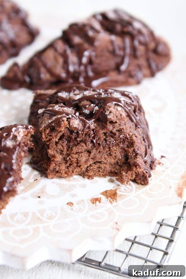 Divine Triple Chocolate Scones 11 A perfectly halved Triple Chocolate Scone on a white platter, revealing its moist, chocolate-studded interior.