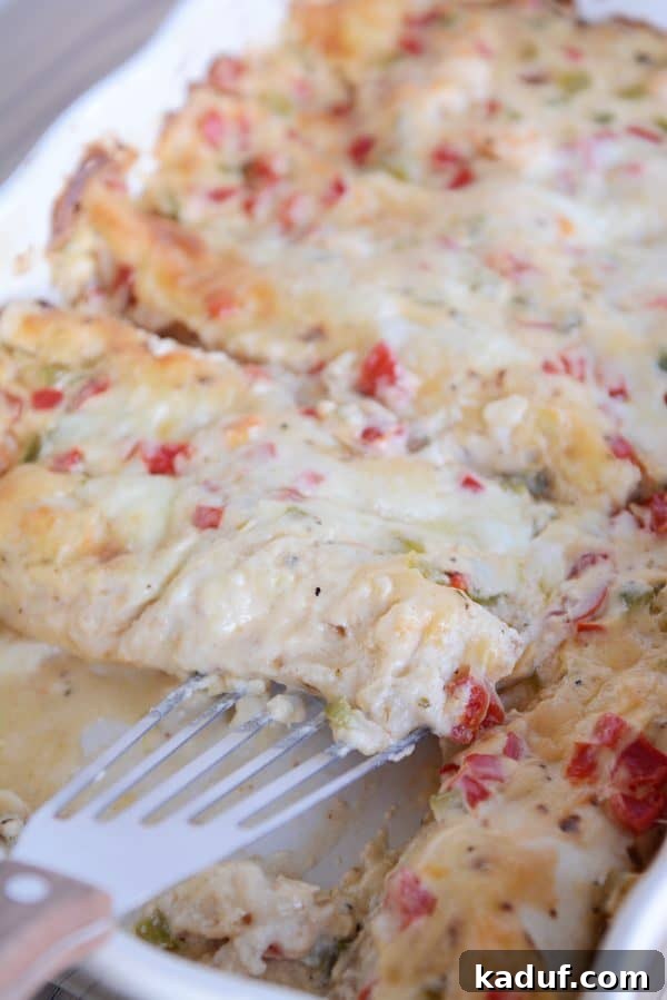 Creamy Shrimp Enchiladas 3 A ceramic baking dish filled with golden-brown shrimp enchiladas covered in creamy white sauce and melted cheese.