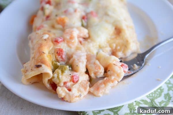 Creamy Shrimp Enchiladas 4 A close-up shot of a shrimp enchilada, showing the creamy filling, melted cheese, and tender shrimp.