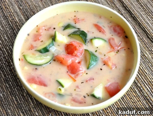 Summer's Bounty Vegetable Soup 3 A close-up, top-down view of the creamy Summer Garden Vegetable Soup, highlighting the generous chunks of zucchini and tomatoes.