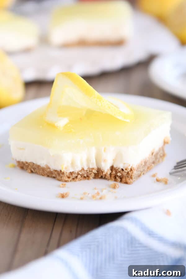 Zesty Lemon White Chocolate Squares 2 Square of lemon white chocolate cream bar on white plate with bite taken out, highlighting the distinct layers.