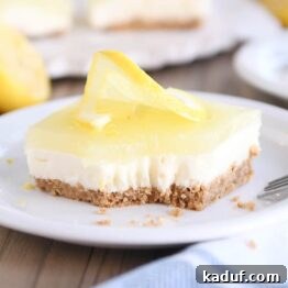 Square of lemon white chocolate cream bar on white plate with bite taken out
