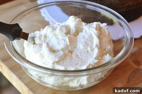 The Ultimate Magical Frosting 4 A glass bowl full of white frosting with an offset spatula inside the bowl.