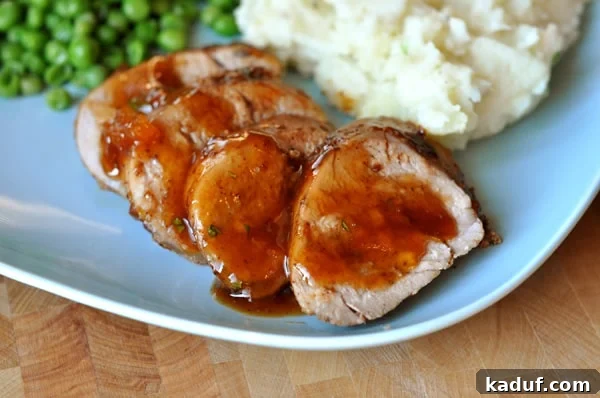 Sweet Heat Apricot Pork 2 Slices of chili-rubbed pork with apricot glaze, accompanied by creamy mashed potatoes and vibrant green peas, arranged beautifully on a blue plate.