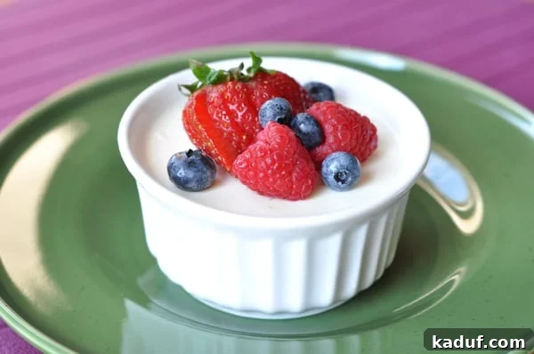 Aspen Gold Crème 2 Small white ramekin filled with cream and topped with fresh berries.