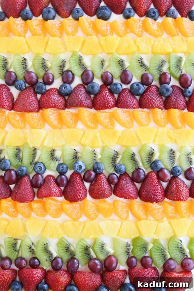 The Perfected Fruit Pizza 2 Rows of kiwi, red grapes, blueberries, strawberries, mandarin oranges and pineapple on fruit pizza.