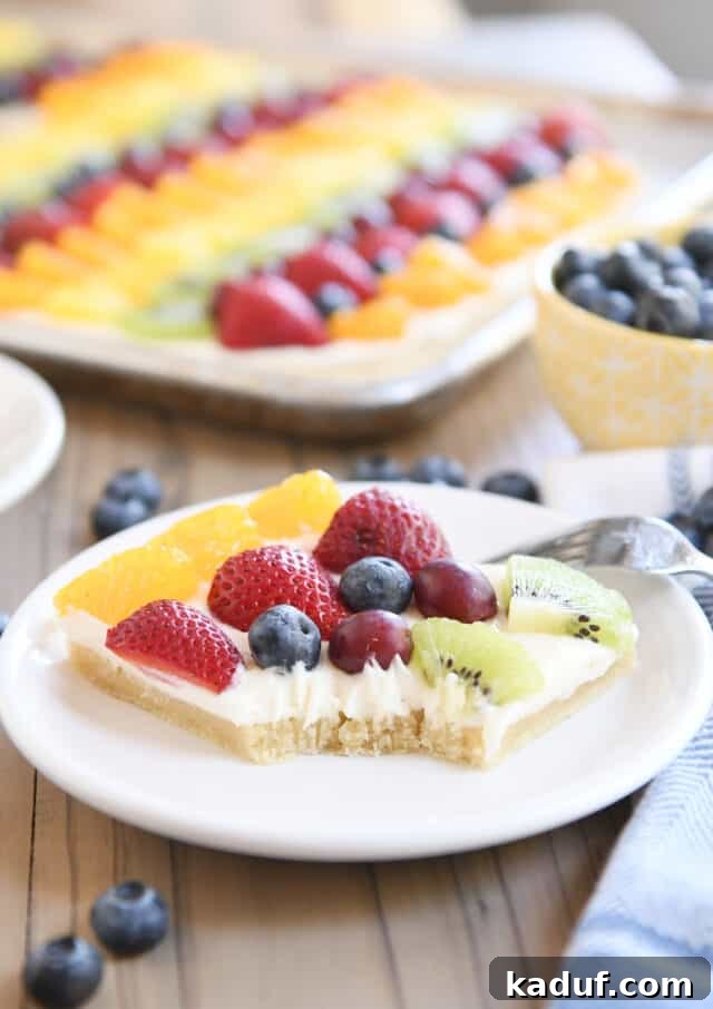 The Perfected Fruit Pizza 3 Square of the best fruit pizza with bite taken out on white plate.