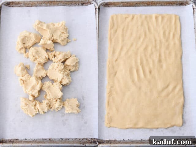 The Perfected Fruit Pizza 5 Sugar cookie dough crumbled on parchment lined sheet pan and then pressed into rectangle shape.