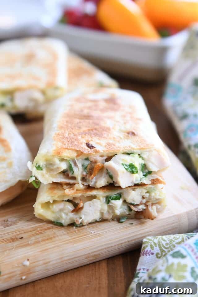 Ultimate Crispy Chicken Bacon Ranch Wraps 2 Two halves of crispy wrap stacked on each other on wood cutting board.