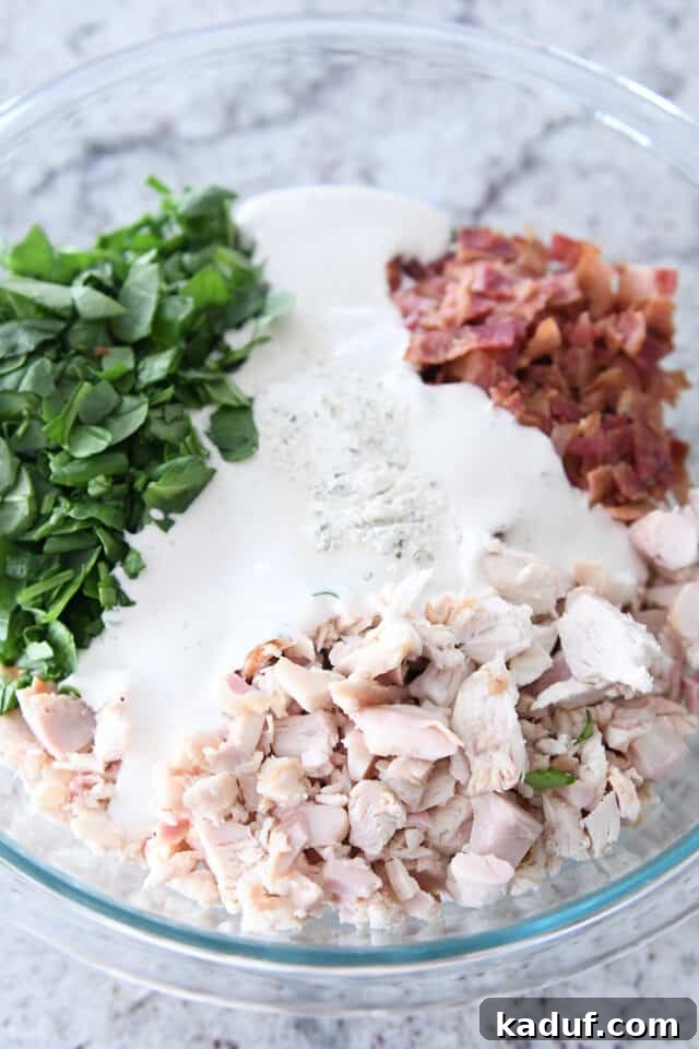 Ultimate Crispy Chicken Bacon Ranch Wraps 3 Glass bowl with chicken, spinach, bacon, ranch dressing.