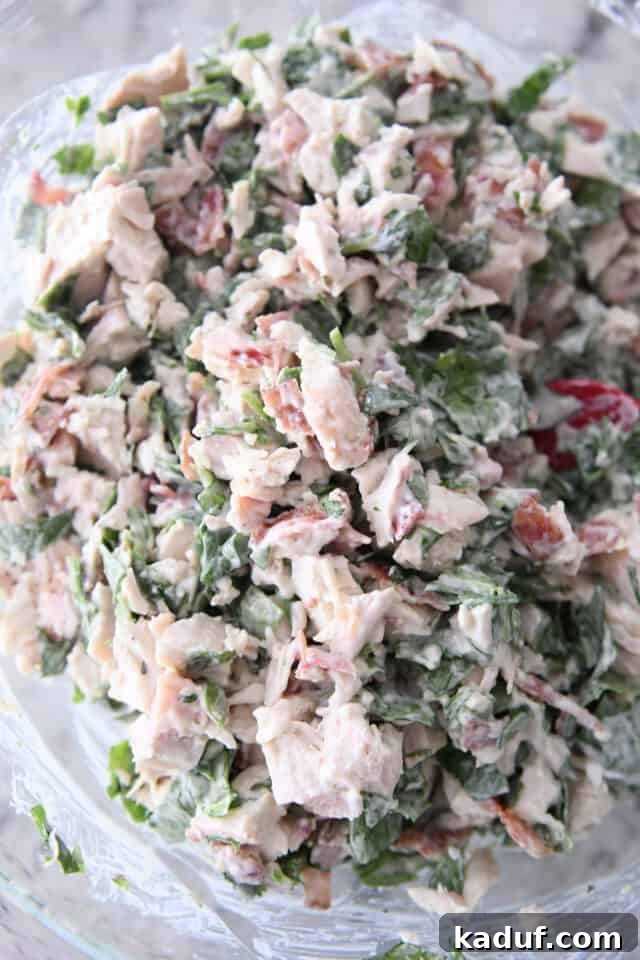 Ultimate Crispy Chicken Bacon Ranch Wraps 4 Glass bowl with chicken, spinach, bacon and ranch dressing mixed together.