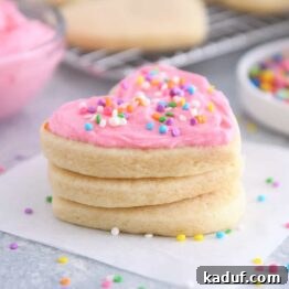 The Ultimate Cutout Sugar Cookie Recipe 12 Frosted sugar cookie stacked on two unfrosted sugar cookies.