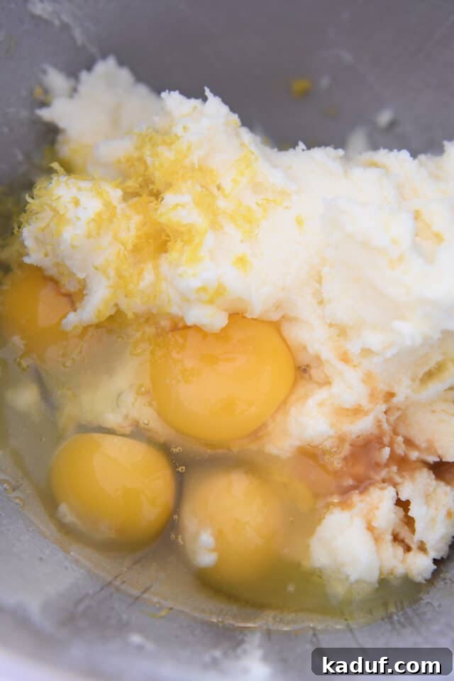 The Ultimate Cutout Sugar Cookie Recipe 4 Eggs, butter, lemon zest and vanilla in stainless bowl.