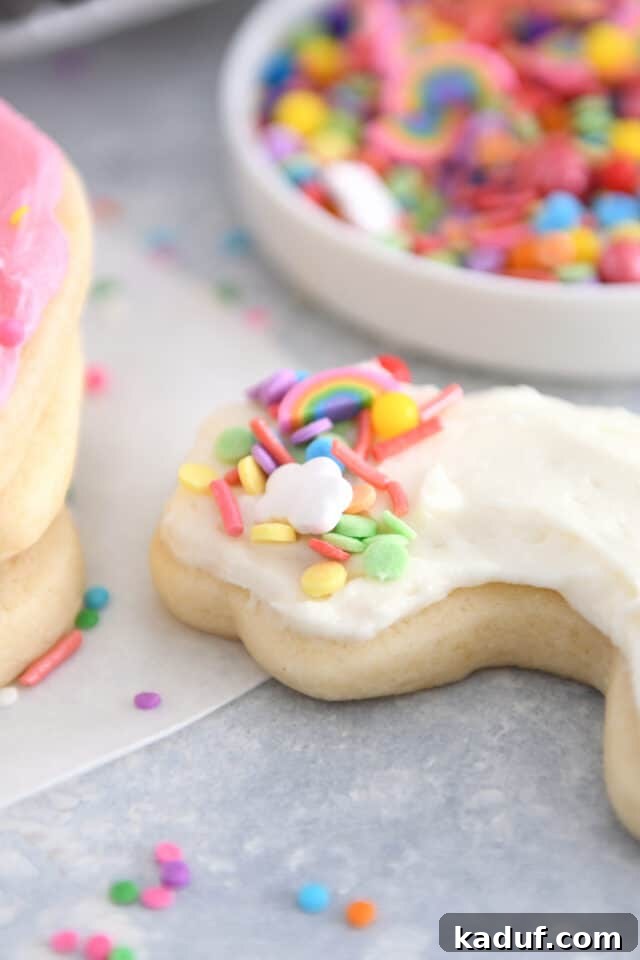 The Ultimate Cutout Sugar Cookie Recipe 10 Rainbow shaped sugar cookie frosted with white frosting and colorful sprinkles.