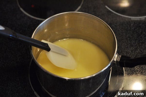 Golden Almond Toffee 9 Melted butter in a saucepan with a spatula in the pan as well, showing the smooth consistency before boiling for almond roca.