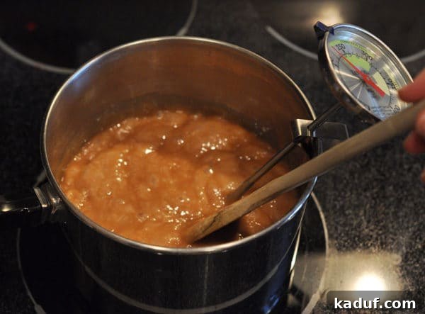 Golden Almond Toffee 14 Golden brown caramel mixture bubbling in a saucepan, now a deeper shade, nearing the hard crack stage for almond roca.