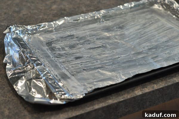 Golden Almond Toffee 5 Buttered and tinfoil lined cookie sheet, a crucial step for preventing stickiness with homemade almond roca.