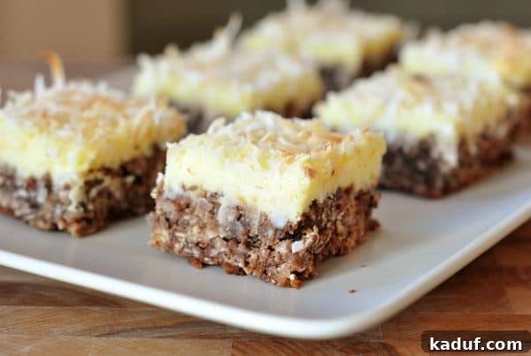 Chocolate Haystack Cheesecake Bars 2 White platter with squares of cream cheese chocolate bars.