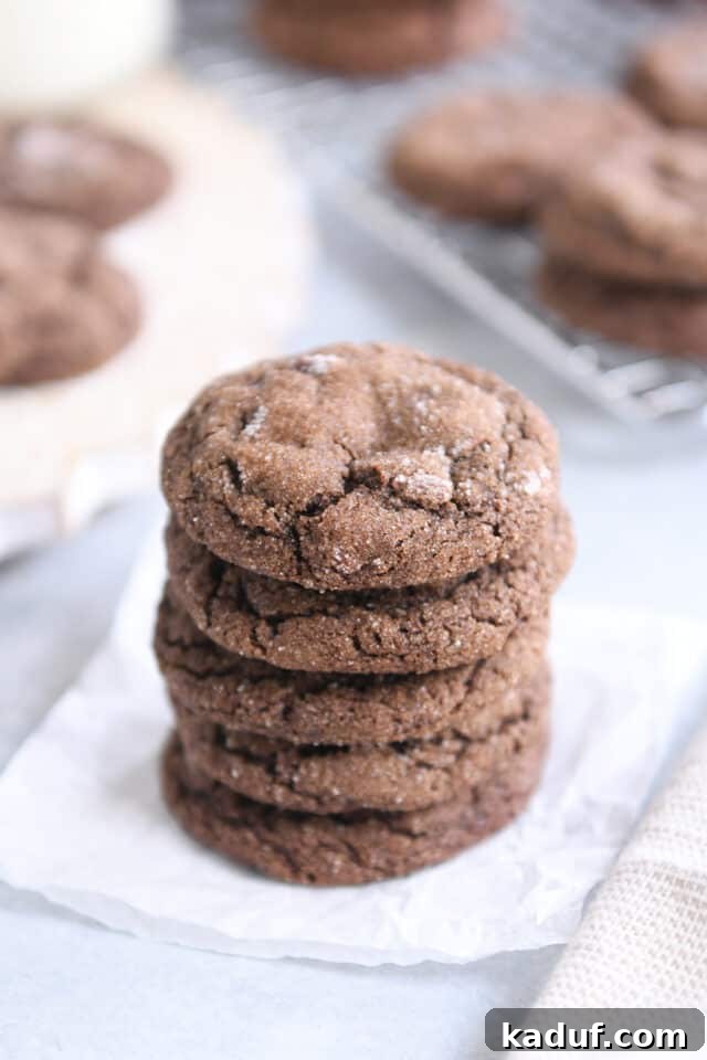 Pillowy Chocolate Ginger Molasses Chews 3 Stack of five chewy chocolate ginger molasses cookies on white parchment paper.