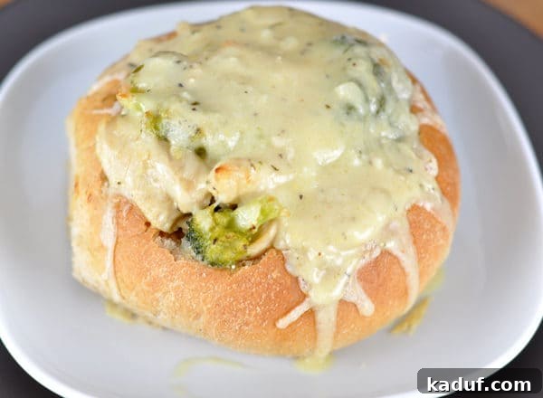 Chicken Cordon Bleu Bread Bowls 3 An overhead view of a hearty bread bowl, filled with a vibrant chicken and broccoli mixture, glistening with melted cheese.