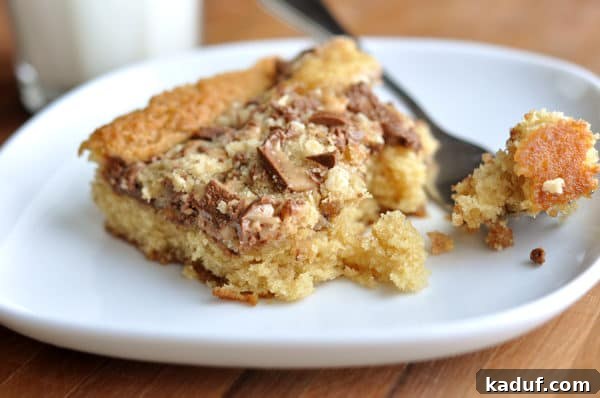 Buttery English Toffee Crunch Cake 2 A slice of toffee-topped Heath Bar cake on a white plate, showcasing the decadent candy layer.
