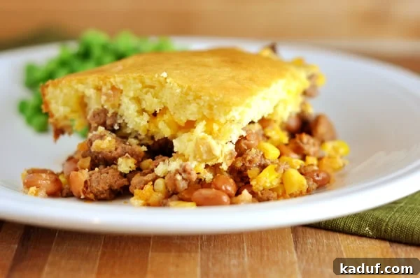 Ranch-Style Beef and Bean Cornbread Bake 9 A beautifully plated portion of Bean and Corn Cornbread-Topped Dinner on a white plate, highlighting the comforting layers and textures.