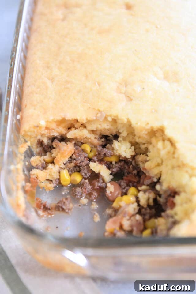 Ranch-Style Beef and Bean Cornbread Bake 6 A delicious 9x13-inch glass pan filled with the baked Cowboy Dinner Casserole, showcasing the golden-brown cornbread topping and rich filling peeking through.