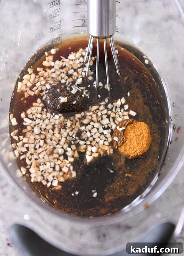 Tropical Ginger-Lime Chicken Tenders with Coconut Rice 3 Liquid measuring cup with garlic, soy sauce, brown sugar, curry powder.