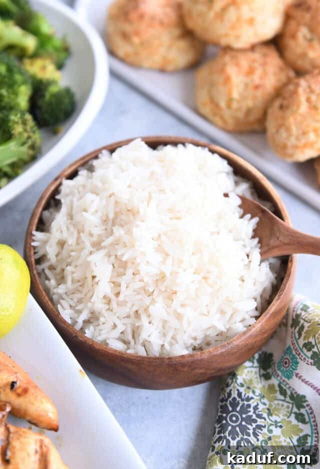 Tropical Ginger-Lime Chicken Tenders with Coconut Rice 6 Coconut rice in wooden bowl with wooden spoon.